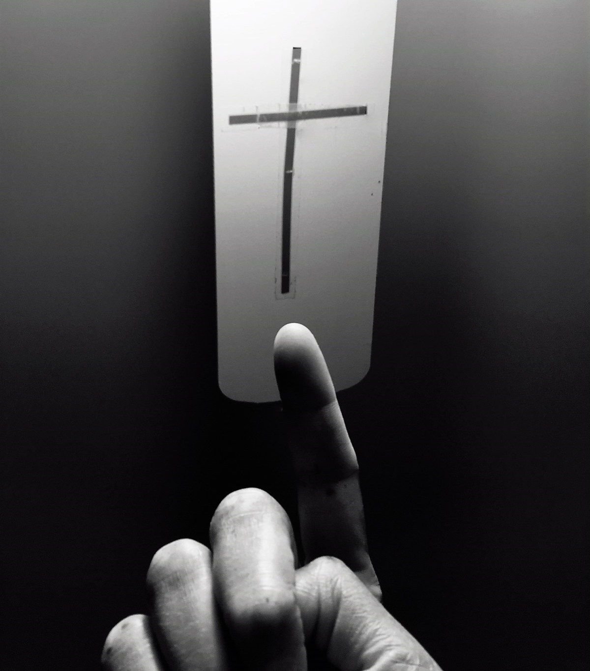 finger pointing to a cross